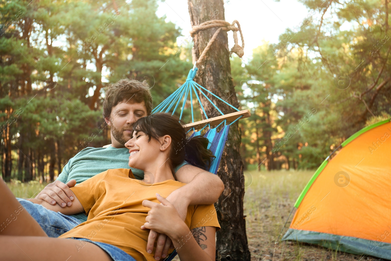 Photo of Lovely couple resting in comfortable hammock outdoors