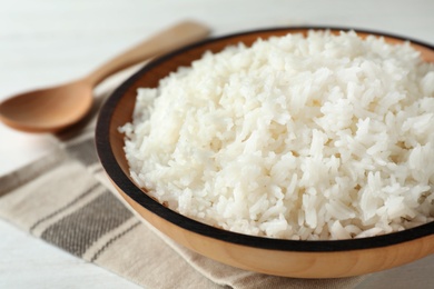 Photo of Bowl of boiled rice on table, closeup