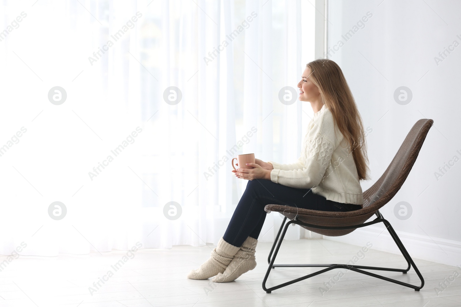 Photo of Young woman resting in armchair at home. Space for text