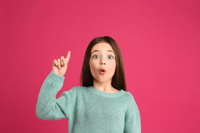 Portrait of cute little girl on pink background