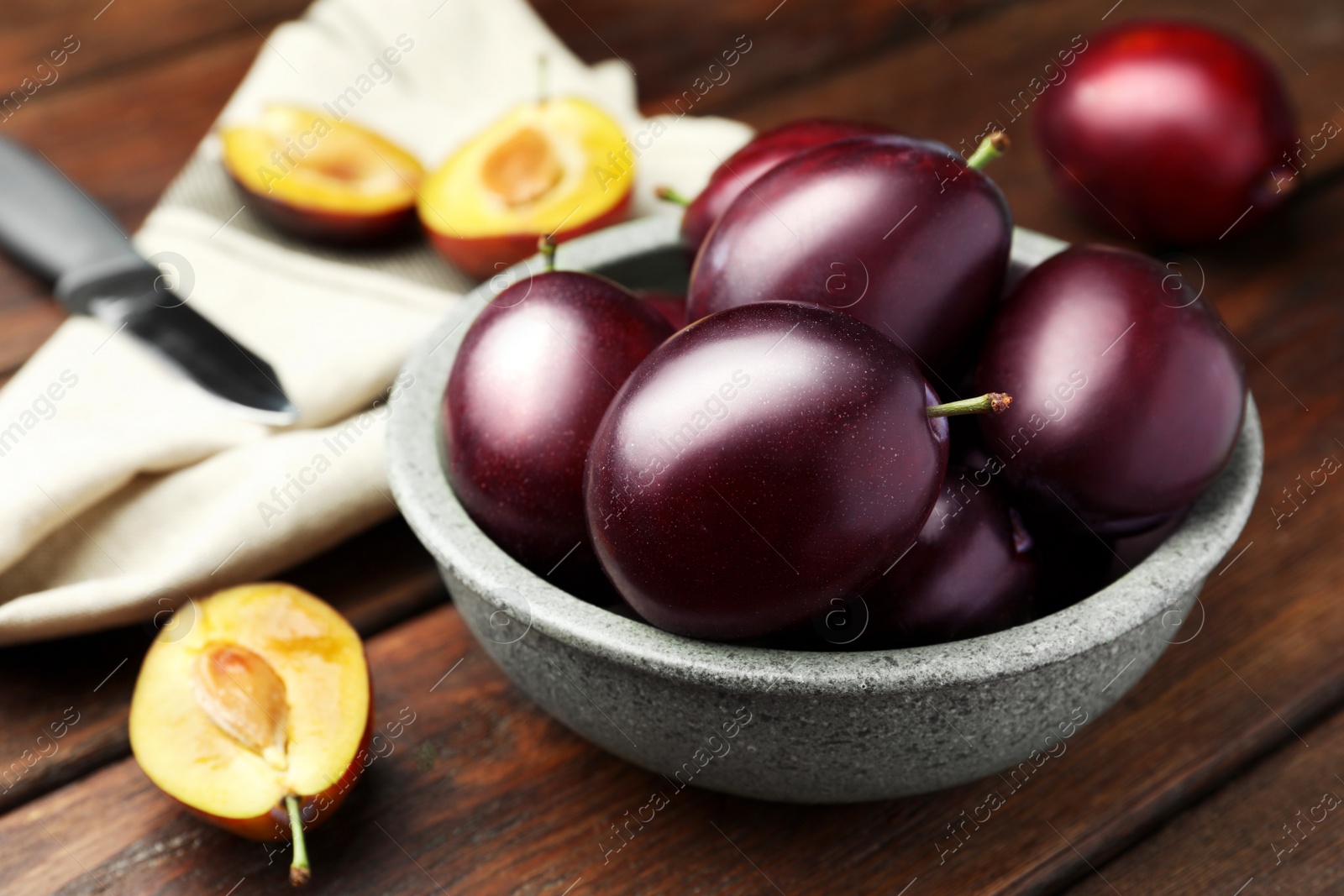 Photo of Tasty ripe plums on wooden table, closeup