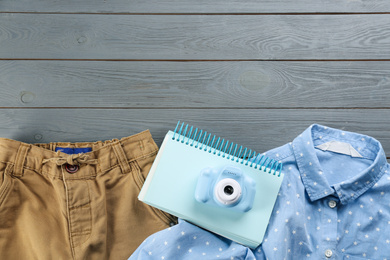 Flat lay composition with little photographer's toy camera on grey wooden background. Space for text