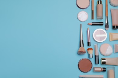 Photo of Face powders and other decorative cosmetic products on light blue background, flat lay. Space for text