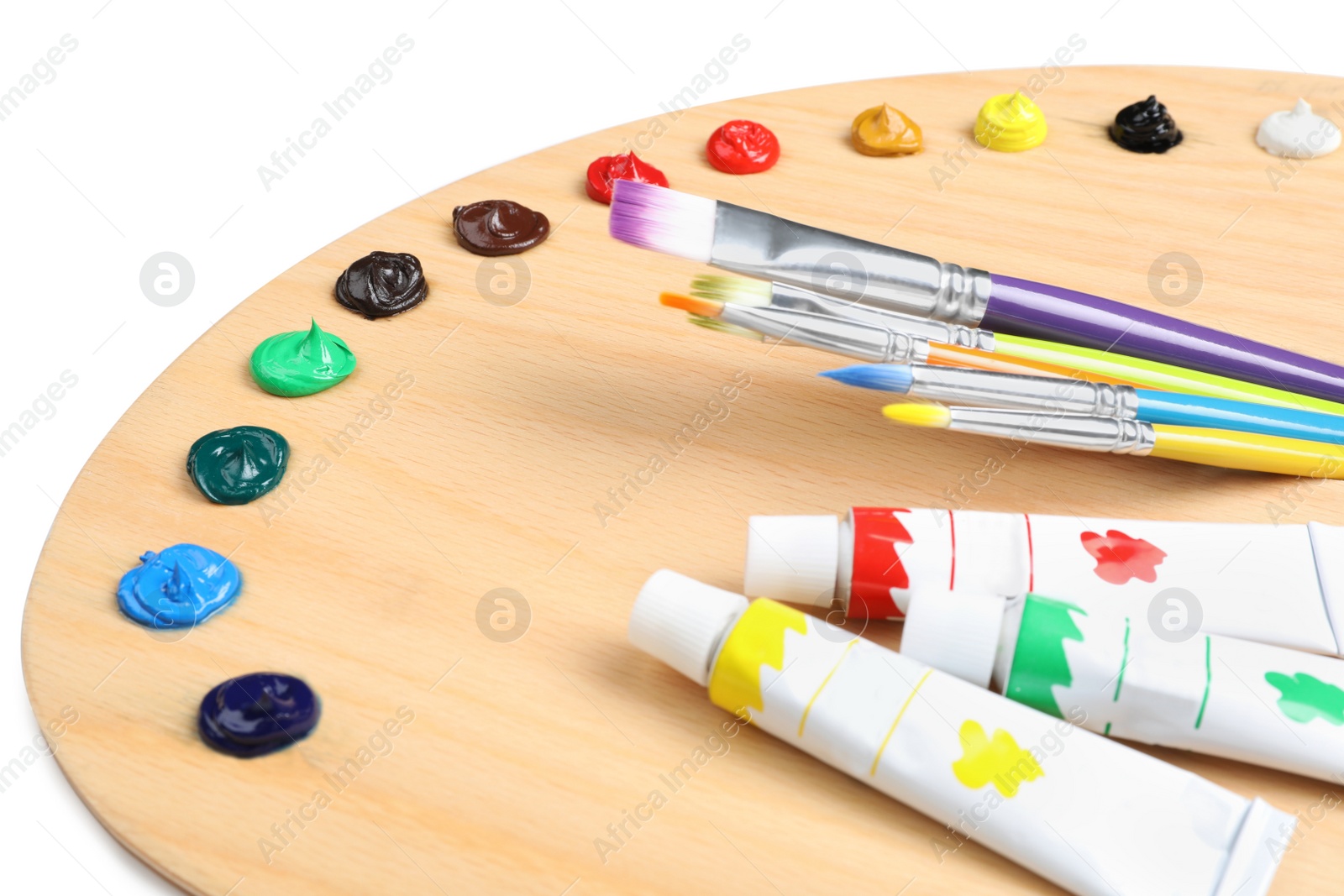 Photo of Palette with acrylic paints and brushes on white background, closeup. Artist equipment