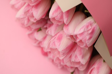 Photo of Beautiful bouquet of fresh tulips on pink background, closeup