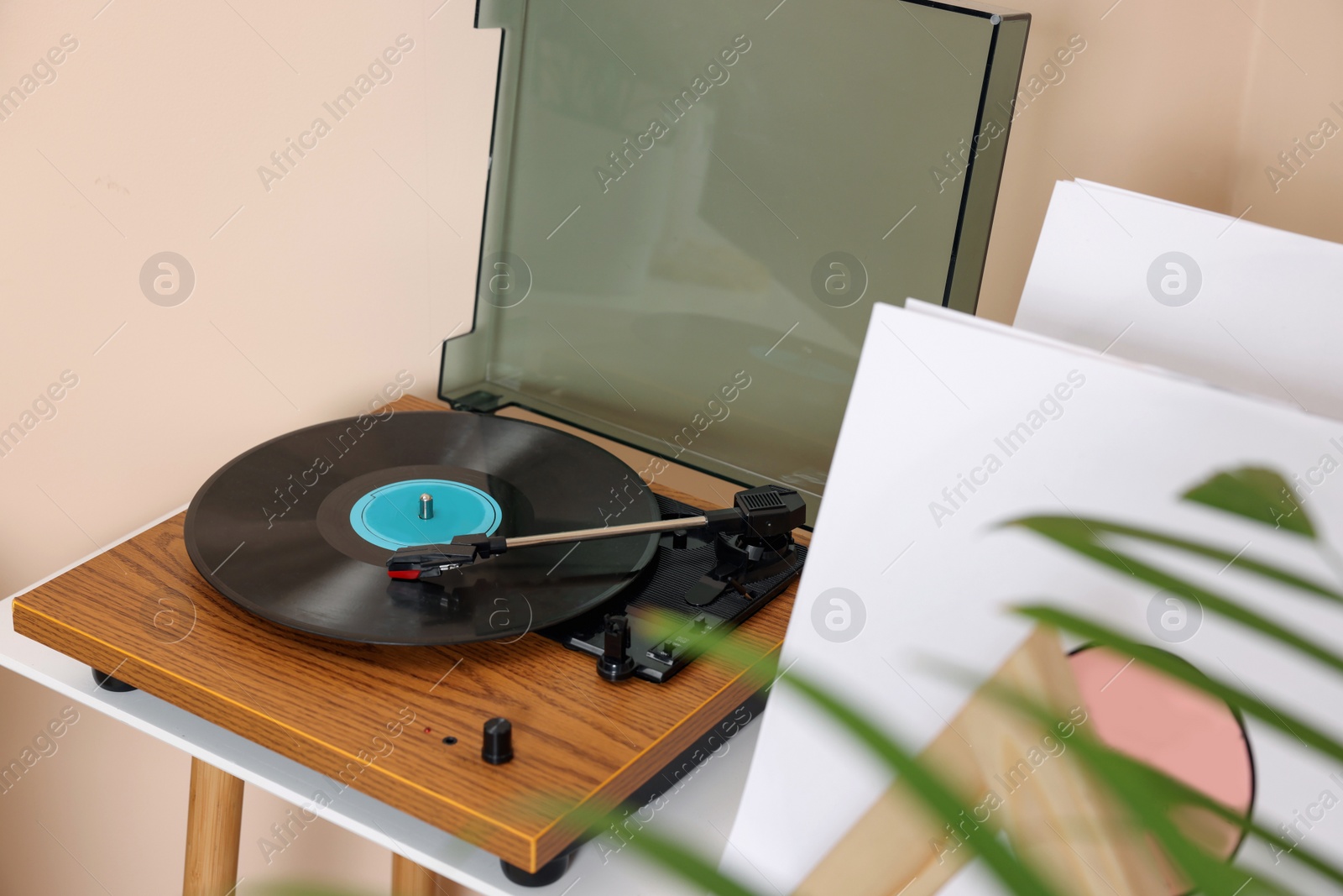 Photo of Stylish turntable with vinyl record on white table indoors