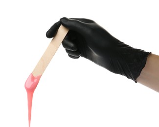 Woman in gloves holding spatula with hot depilatory wax on white background, closeup