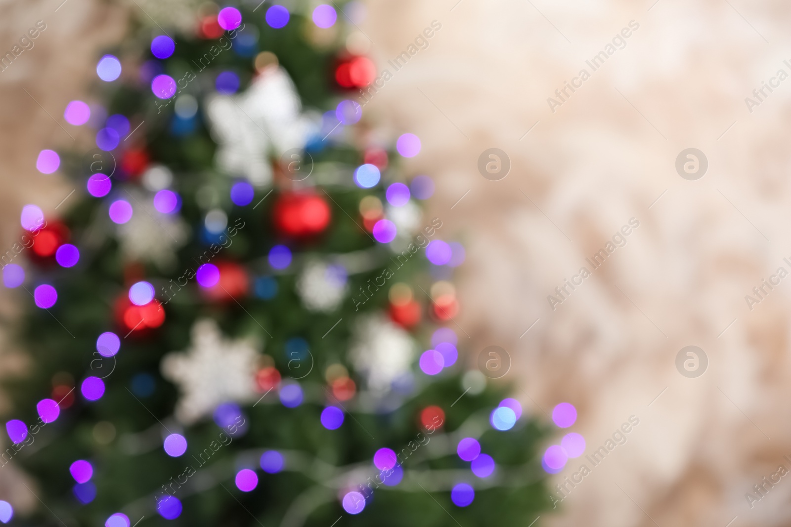 Photo of Beautiful Christmas tree with lights against brown background, blurred view. Space for text