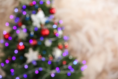 Photo of Beautiful Christmas tree with lights against brown background, blurred view. Space for text