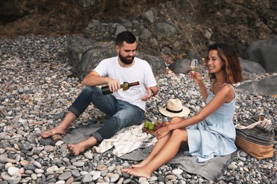 Photo of Happy young couple having picnic on beach