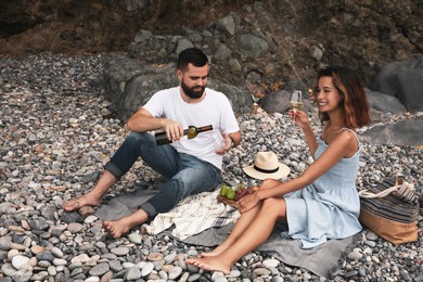 Happy young couple having picnic on beach