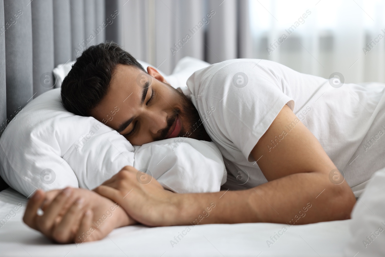 Photo of Handsome man sleeping on bed at morning