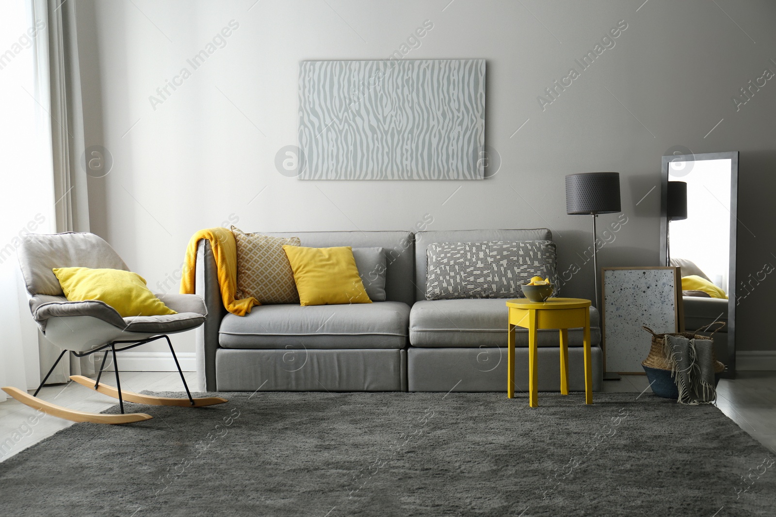 Photo of Stylish living room with sofa. Interior design in grey and yellow colors