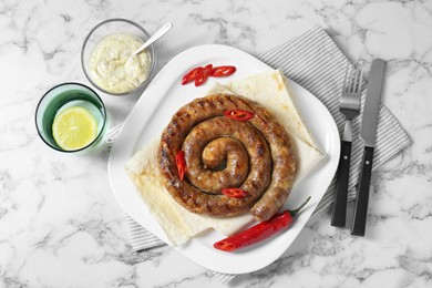 Photo of Tasty homemade sausage with chili pepper and lavash served on white marble table, flat lay