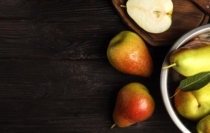 Photo of Ripe juicy pears on black wooden table, flat lay. Space for text