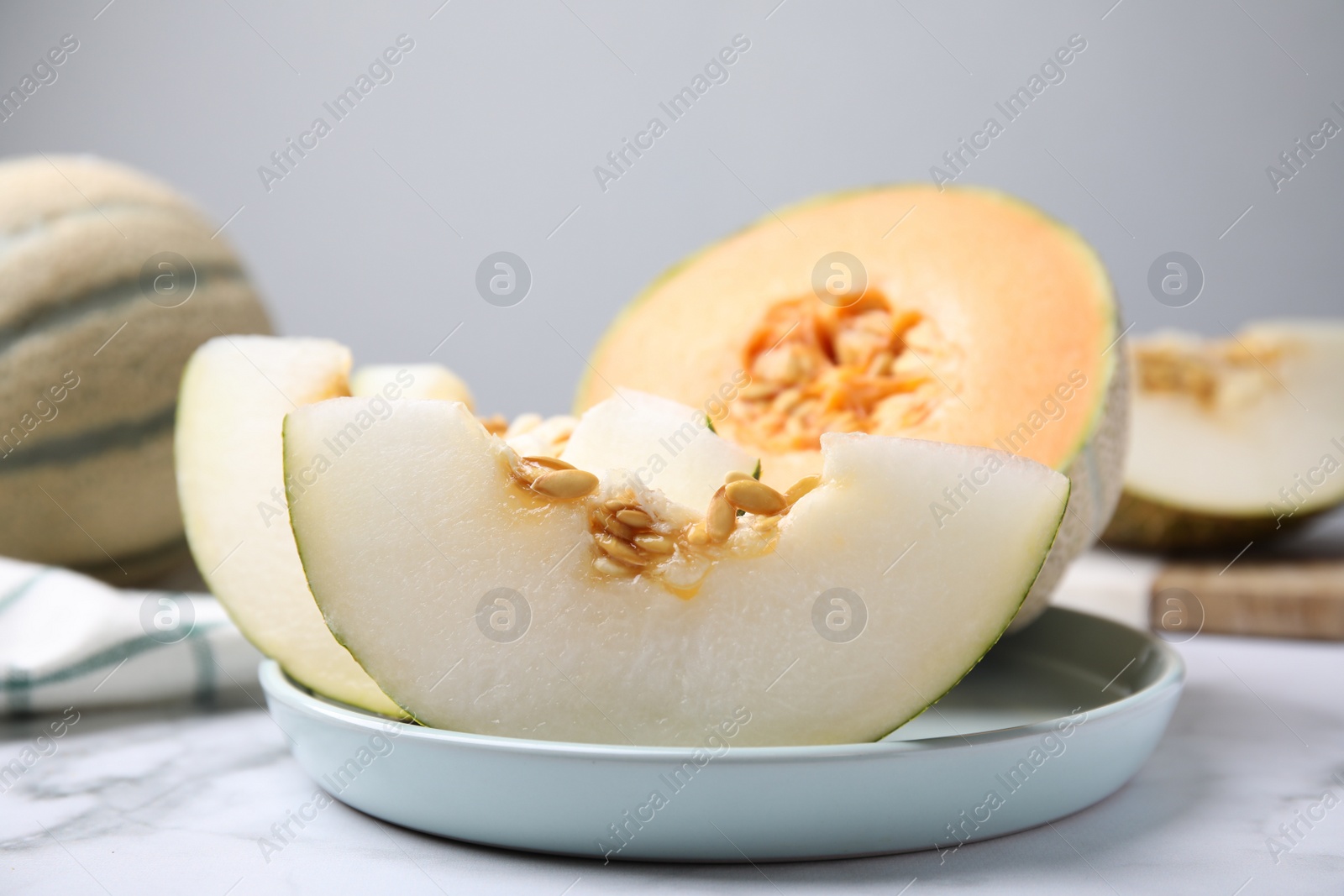 Photo of Tasty colorful ripe melons on white marble table, closeup