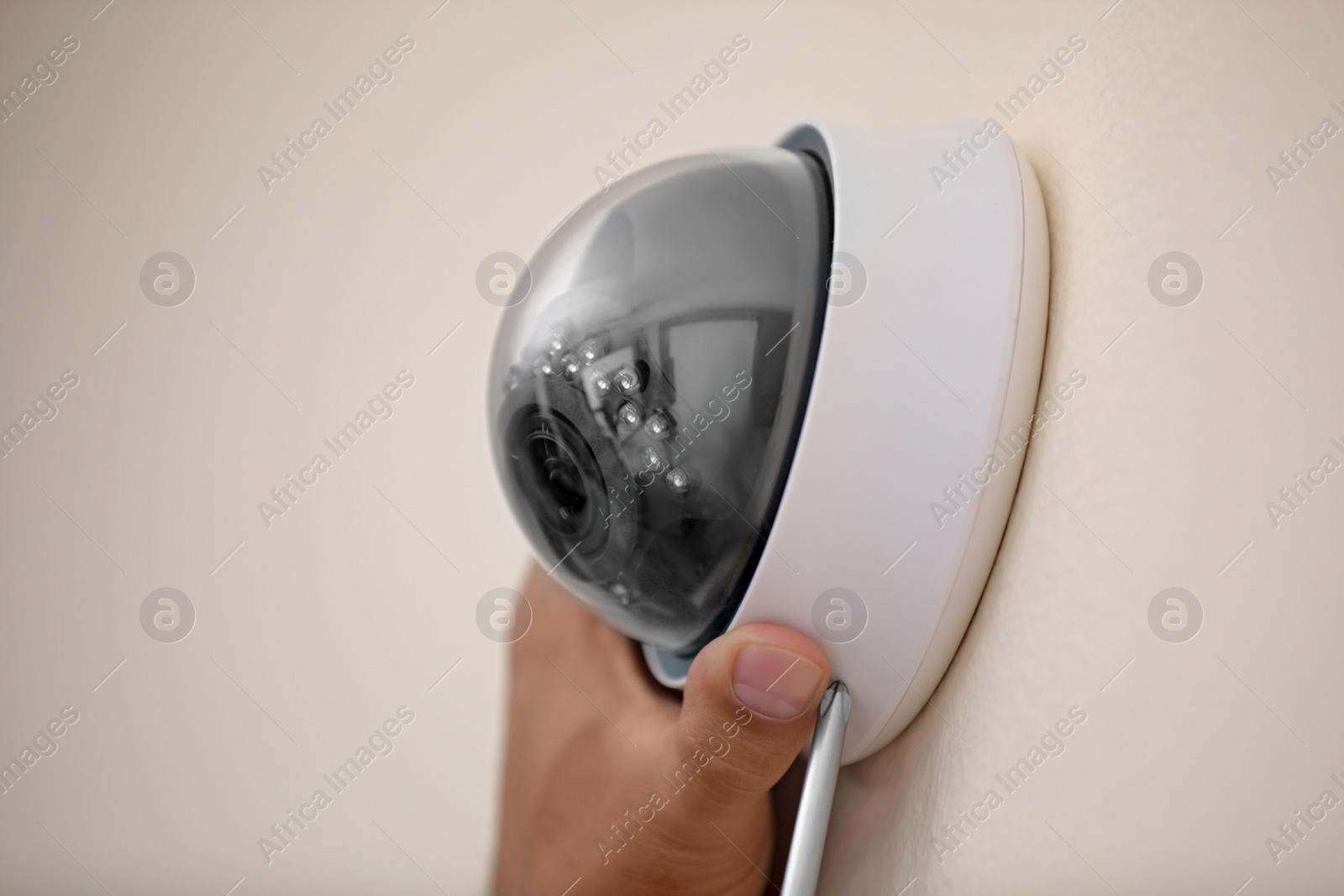 Photo of Technician installing CCTV camera on wall, closeup