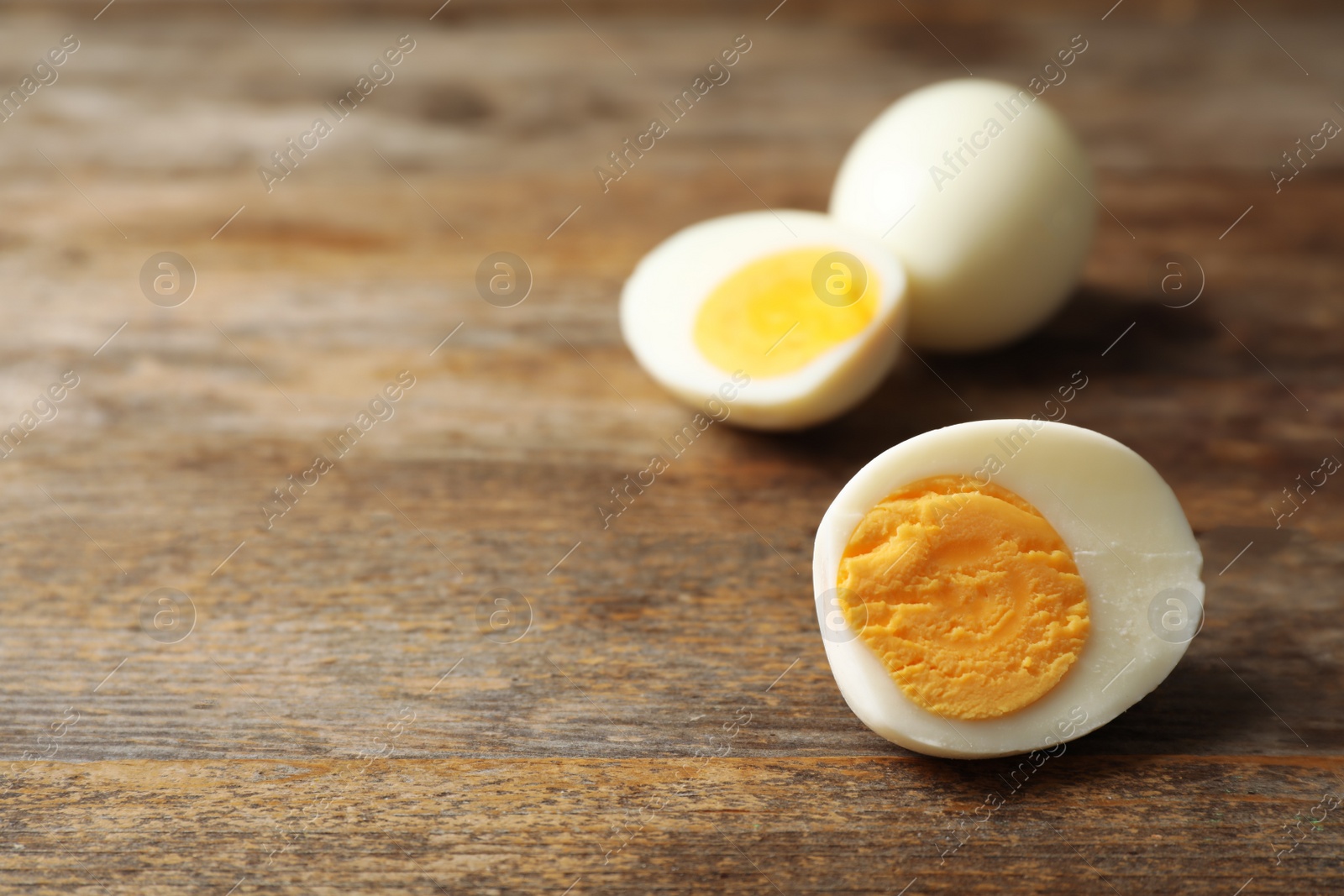 Photo of Hard boiled eggs on wooden table. Space for text