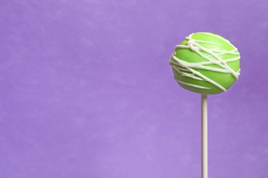 Bright delicious cake pop on color background. Space for text