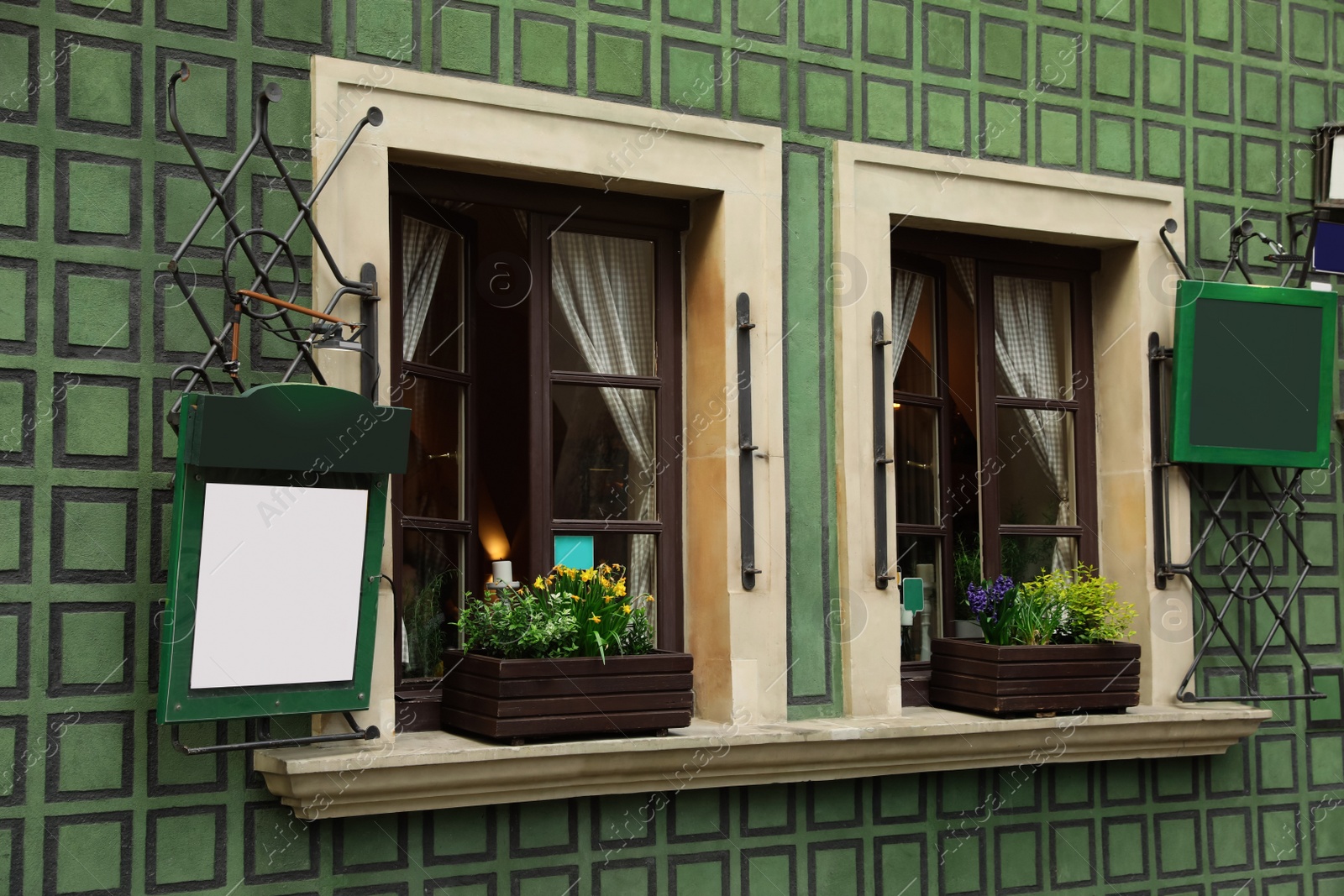 Photo of Building with open windows and flower decor, view from outdoors