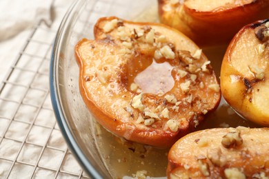 Delicious baked quinces with nuts and honey in bowl on table, closeup