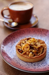 Photo of Plate with delicious cake on wooden table