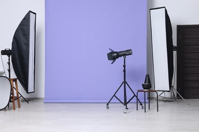Photo of Violet photo background and professional lighting equipment in studio