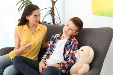 Child psychologist working with boy in office