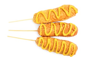 Photo of Delicious deep fried corn dogs with mustard on white background, top view