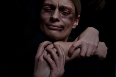 Kidnapper restraining woman on dark background, closeup. Taking hostage