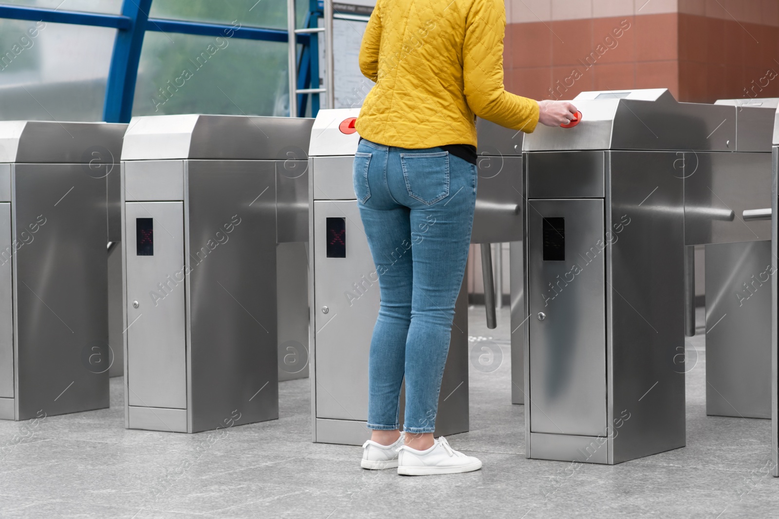 Photo of Woman passing turnstile, closeup view. Fare collection system