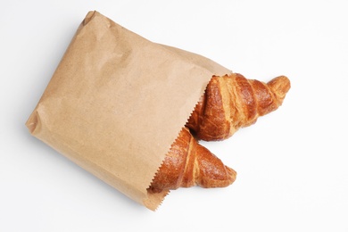 Photo of Paper bag with croissants on white background, top view. Space for design