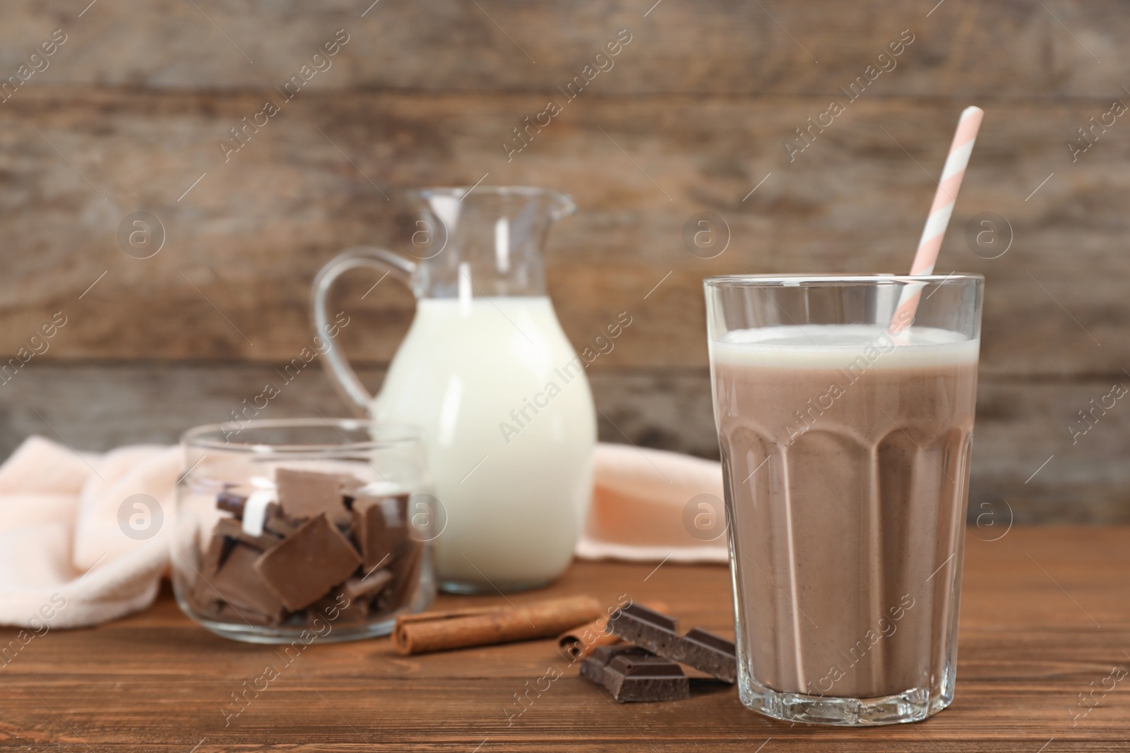 Photo of Glass of chocolate milk on wooden background. Space for text