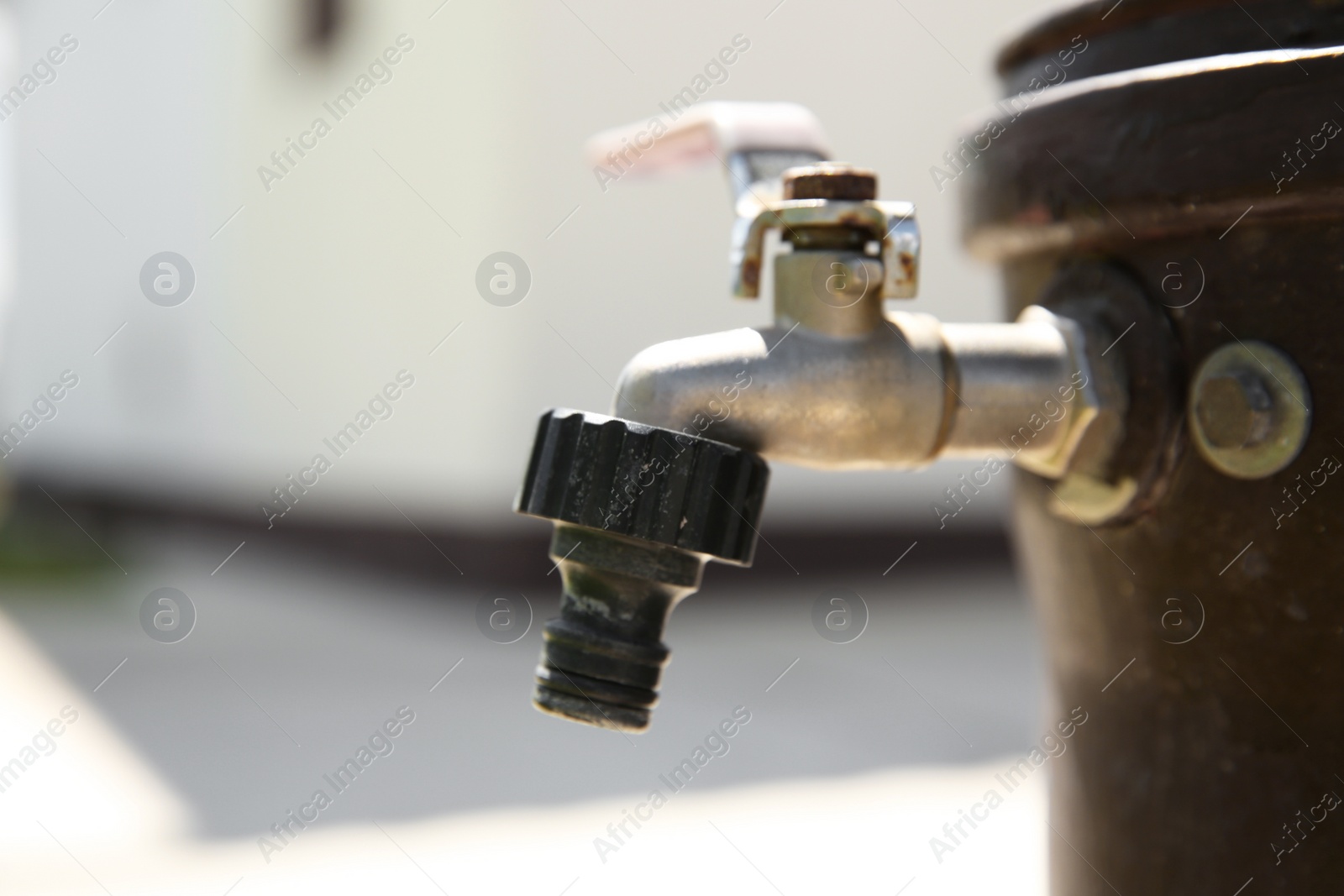 Photo of Metal water tap outdoors, closeup. Space for text