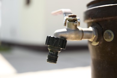 Metal water tap outdoors, closeup. Space for text