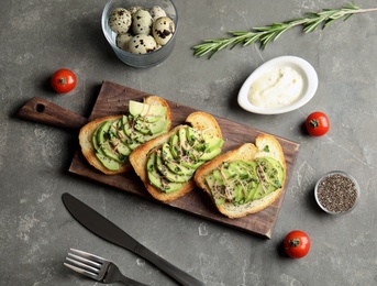 Tasty toasts with avocado, sprouts and chia seeds served on table, top view