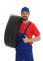 Portrait of professional auto mechanic with tire on white background