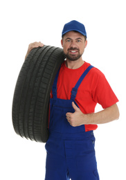 Photo of Portrait of professional auto mechanic with tire on white background