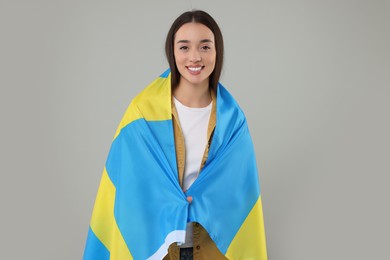 Photo of Young woman with flag of Sweden on light grey background