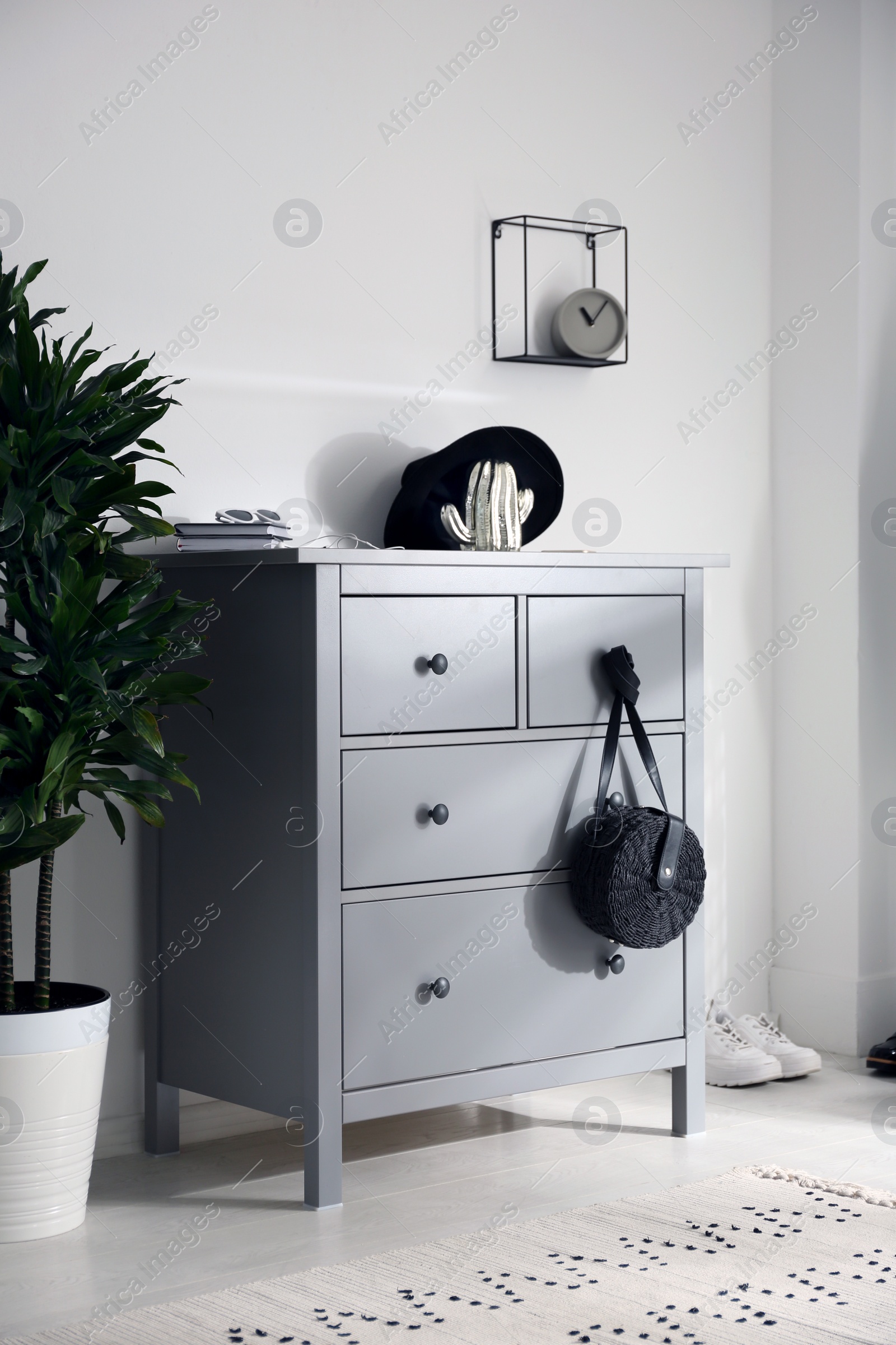 Photo of Grey chest of drawers in stylish room. Interior design