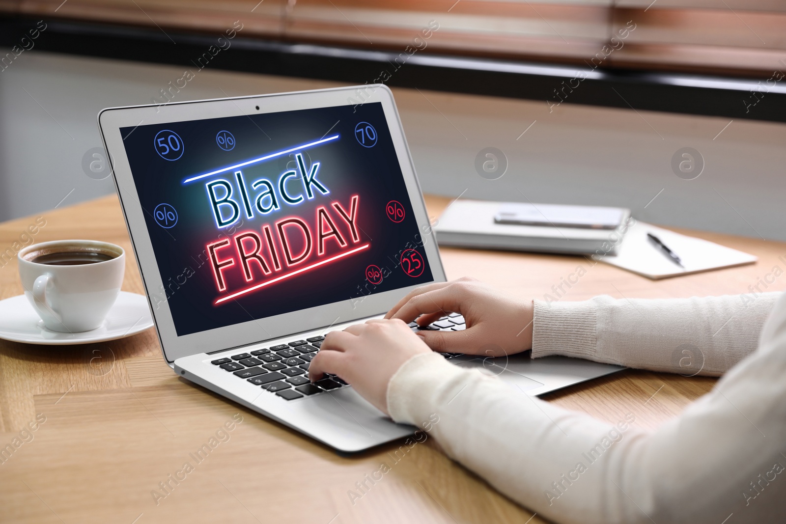 Image of Black Friday. Woman shopping online using laptop at table, closeup