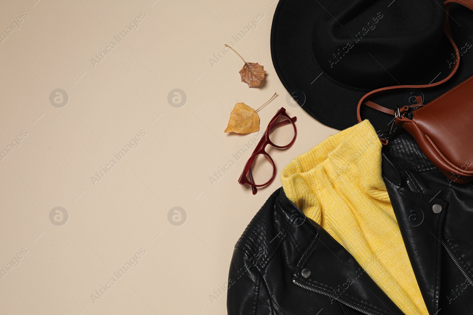 Photo of Flat lay composition with stylish hat and autumn clothes on beige background, space for text