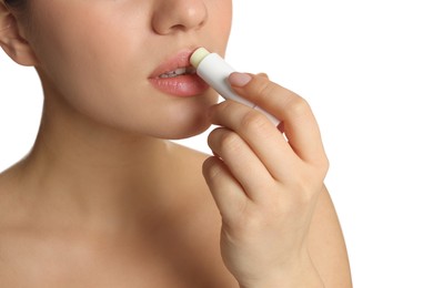 Photo of Young woman applying lip balm on white background, closeup