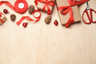 Photo of Flat lay composition with beautiful Christmas gift boxes wrapped in kraft paper on wooden table. Space for text