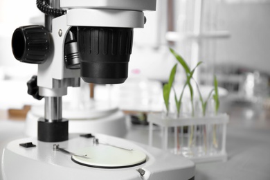 Photo of Modern microscope on table in laboratory, closeup