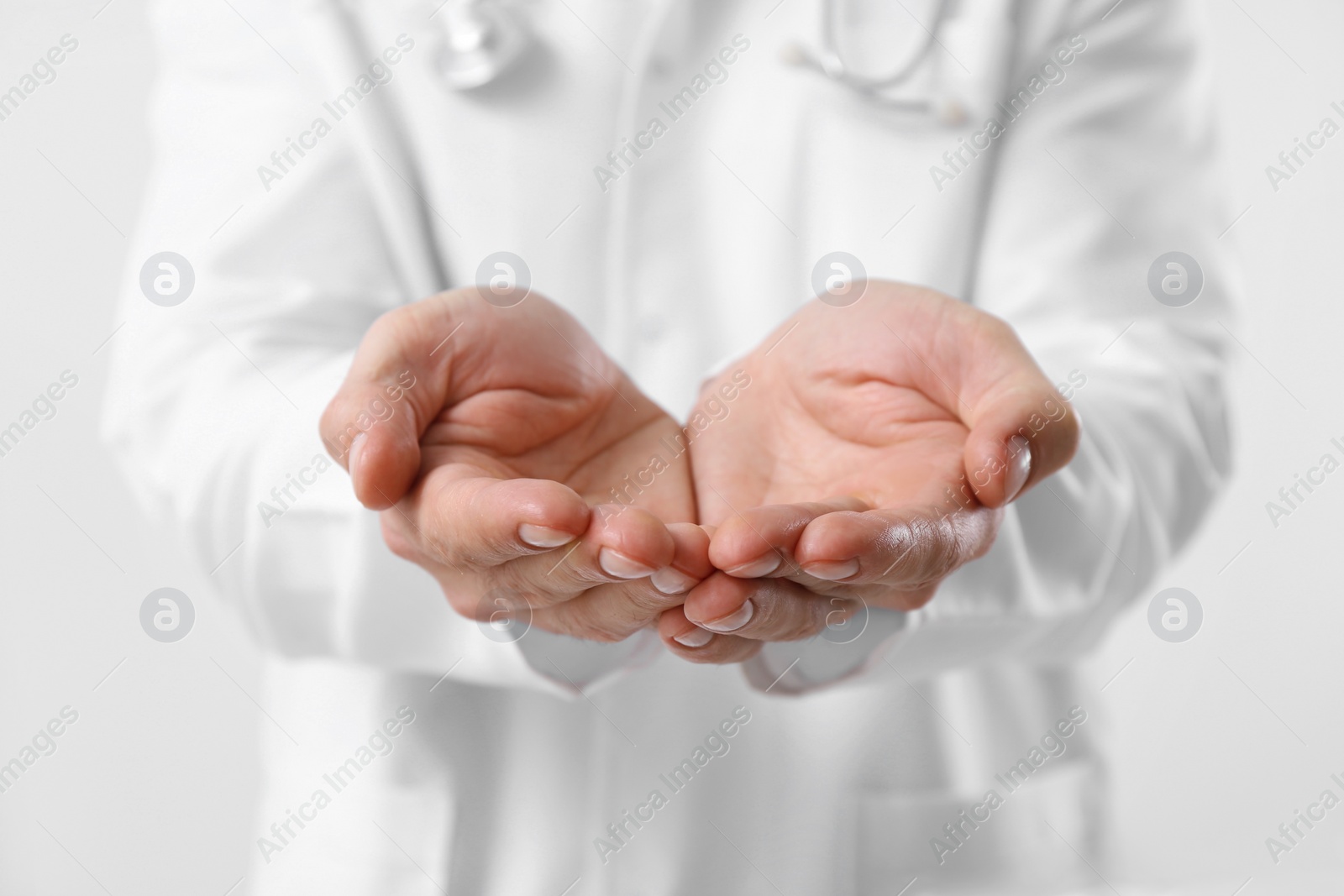 Photo of Doctor holding something on white background, closeup