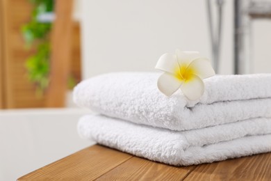 Photo of Stacked towels on tub tray in bathroom, closeup. Space for text