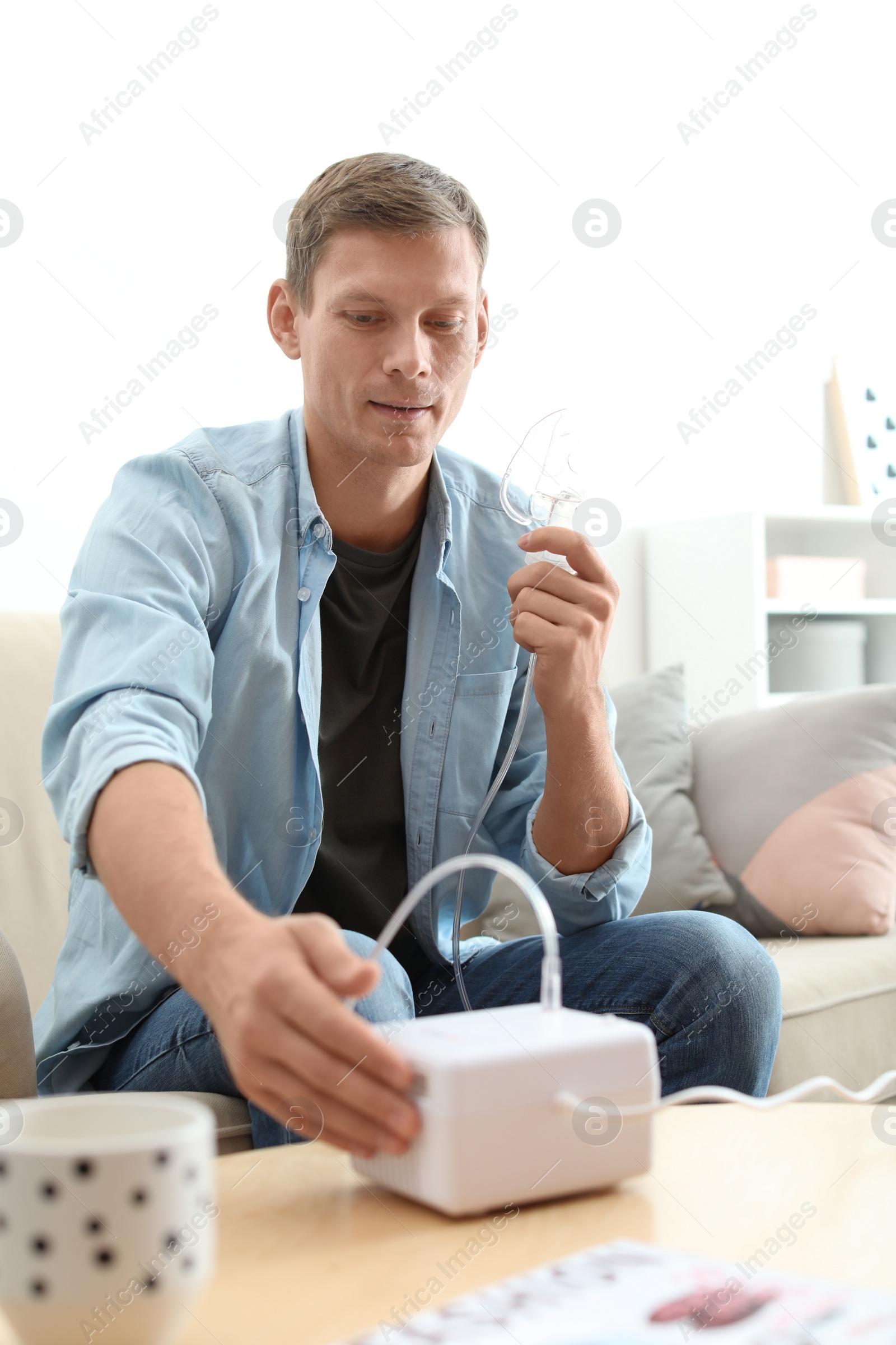 Photo of Man using asthma machine at home. Health care