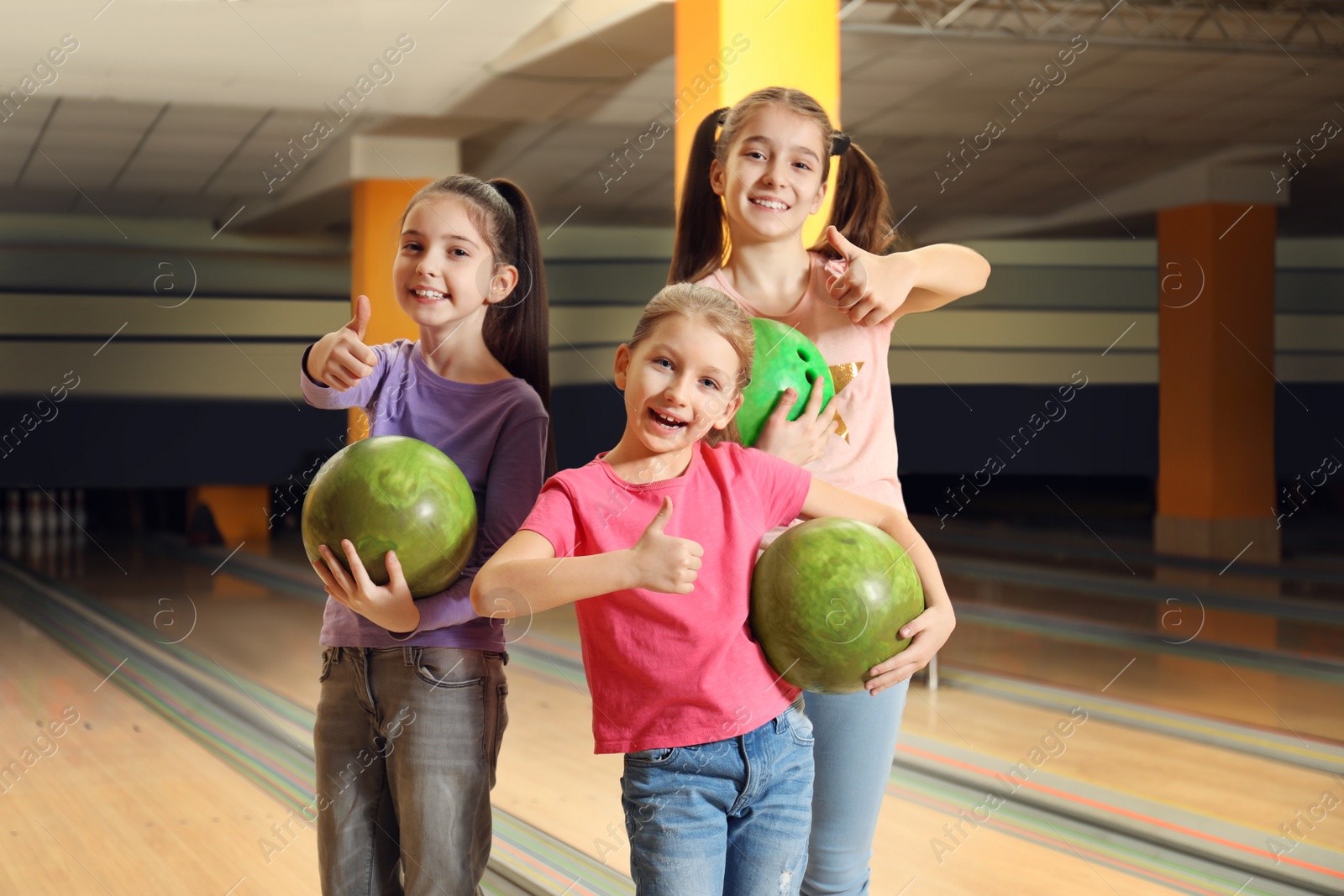 Photo of Happy girls with balls in bowling club