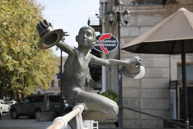 Kutaisi, Georgia - September 2, 2022: Sculpture of boy with hats on white bridge